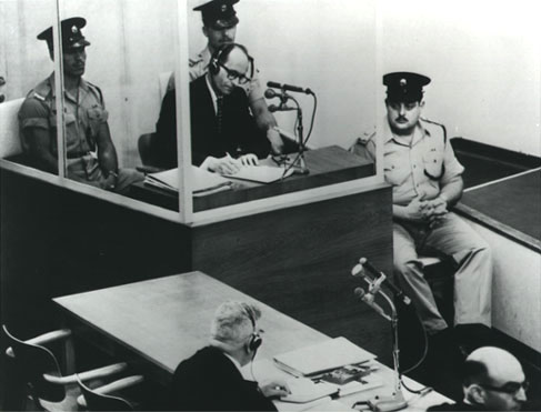 Photo Eichmann in glass booth at trial.