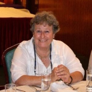 Dr. Chaya Ostrower Beit Berl Academic College, Faculty Member photo sitting at desk with hands together, in a white shirt and smiling